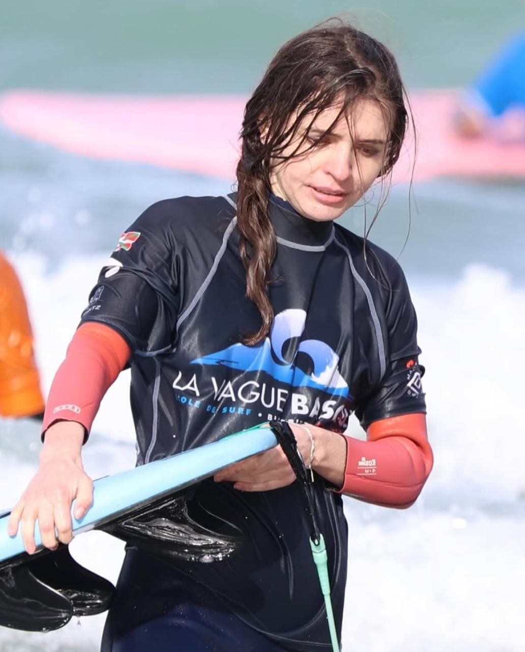 Coming out of the surf carrying a board